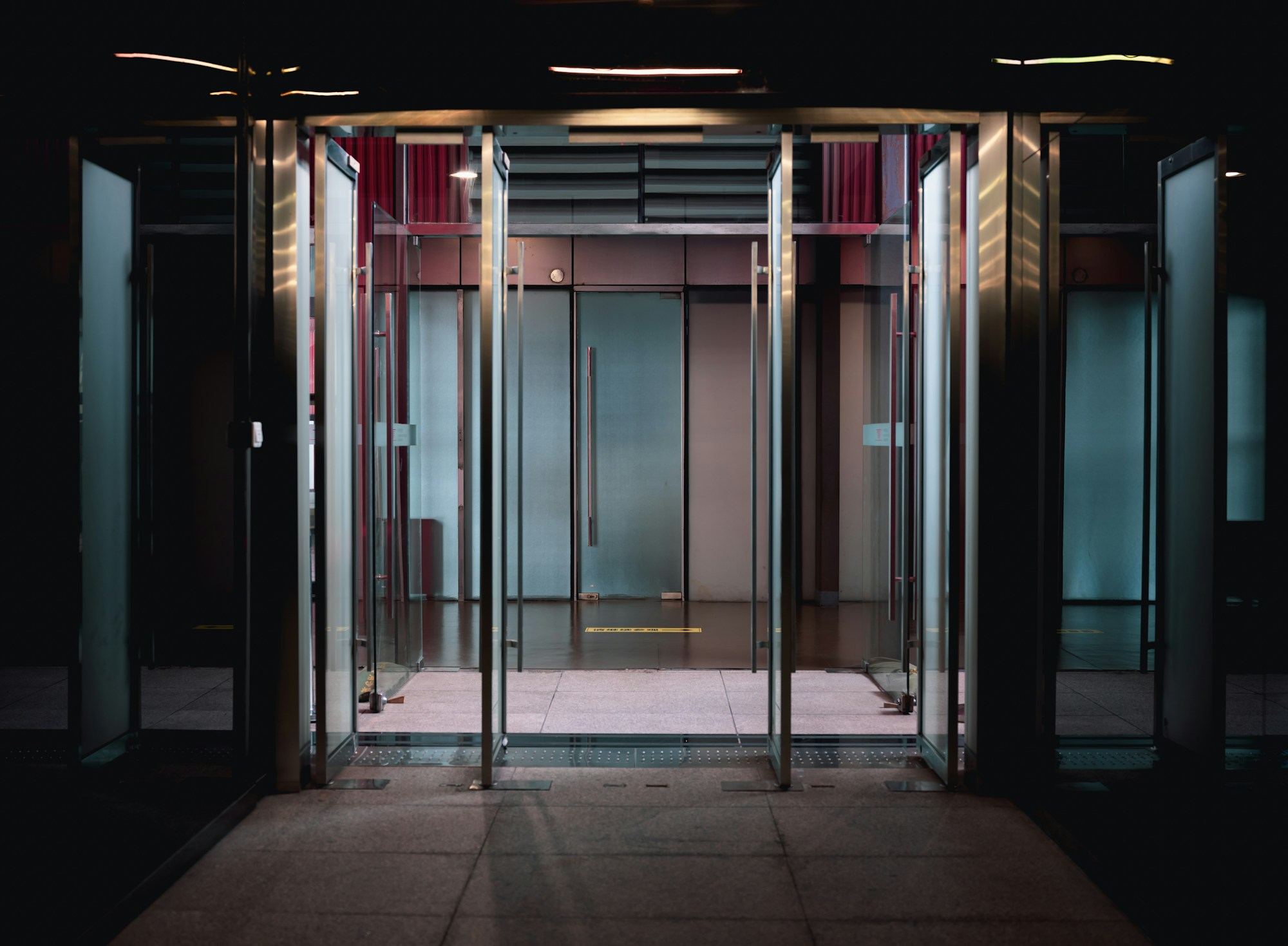 A lobby entrance of tall glass doors in slim steel frames.